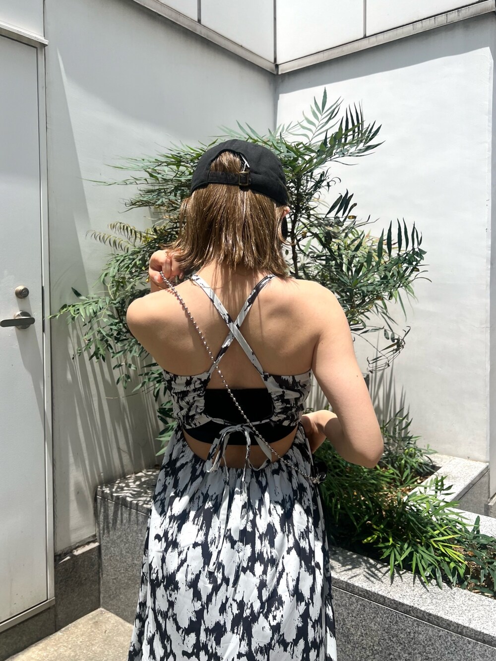 ホワイト系のワンピース、ブラック系のショルダーバッグ、ブラック系のサンダルを着用したレディースの夏コーディネートの6枚目の写真