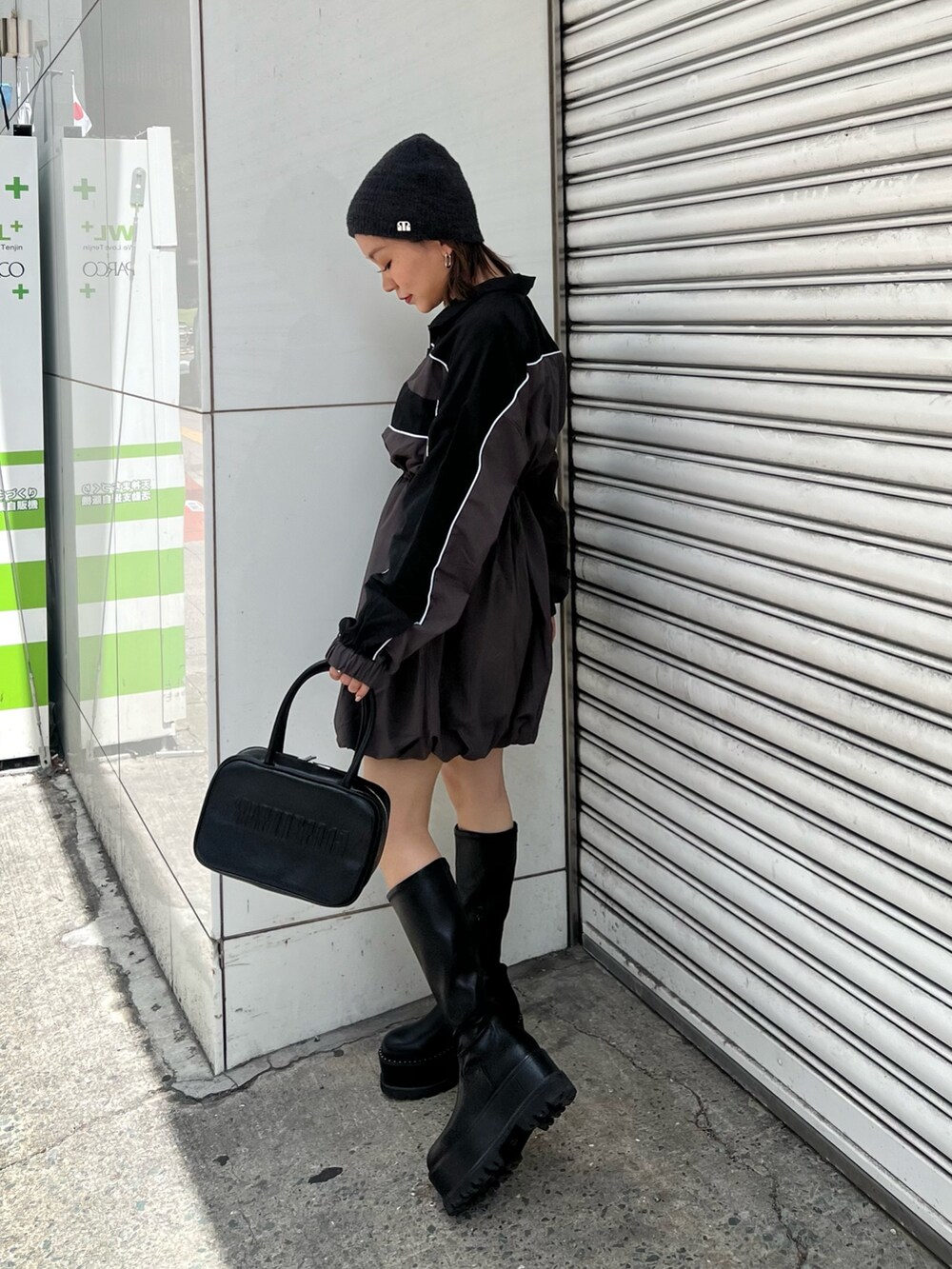 ブラック系のボストンバッグ、ブラック系のワンピース、ブラック系のブーツを着用したレディースの夏コーディネートの4枚目の写真