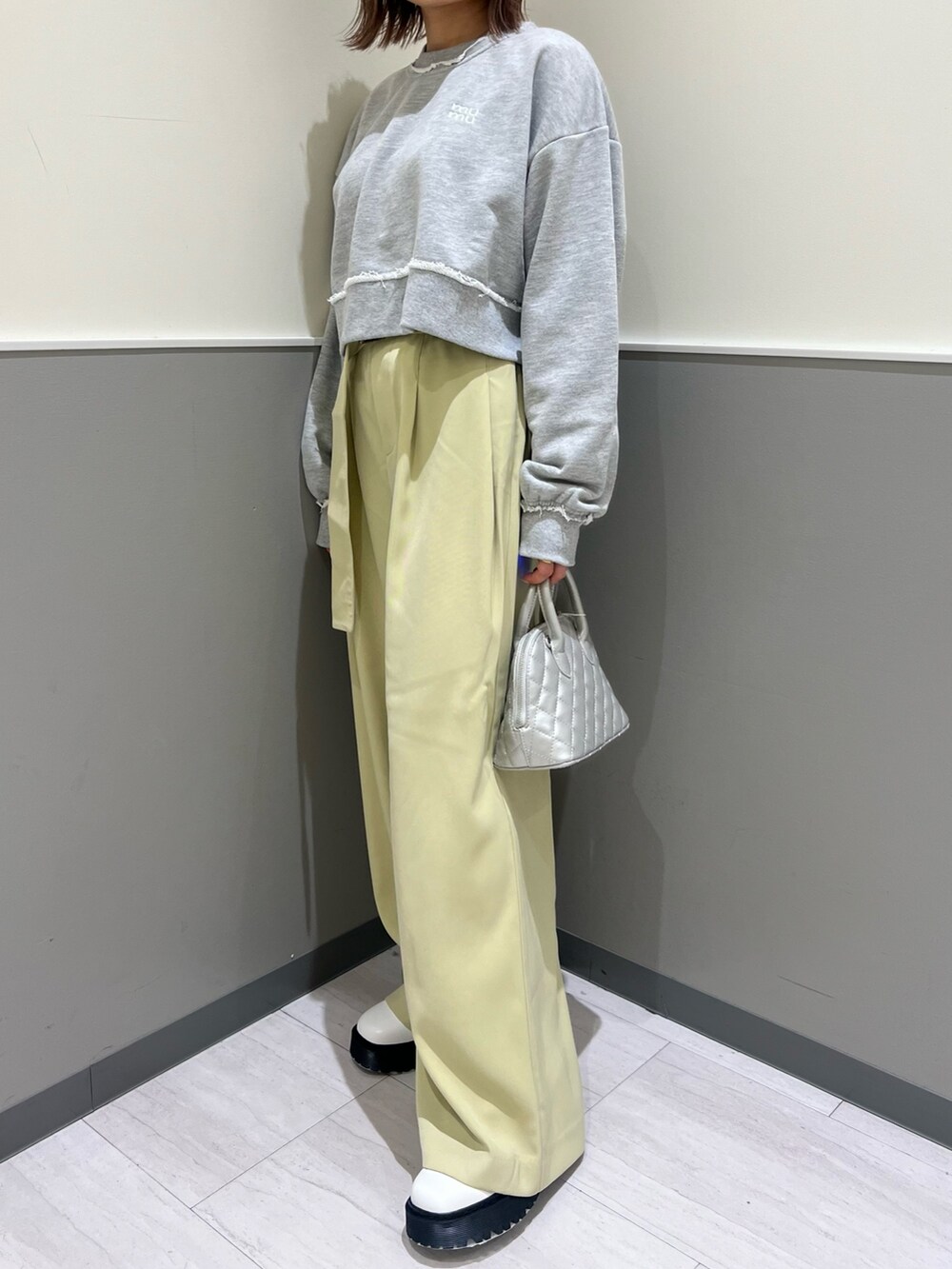 グレー系のスウェット、グリーン系のその他パンツ、シルバー系のハンドバッグを着用したレディースの冬コーディネートの6枚目の写真
