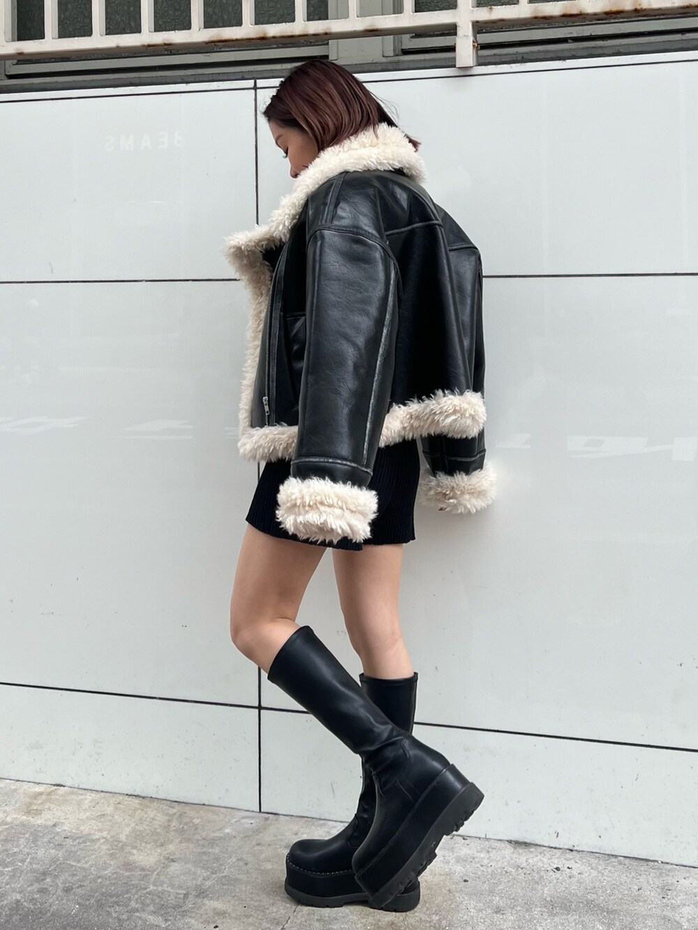 ブラック系のムートンコート、ブラック系のニット/セーター、ブラック系のその他パンツを着用したレディースの秋コーディネートの2枚目の写真