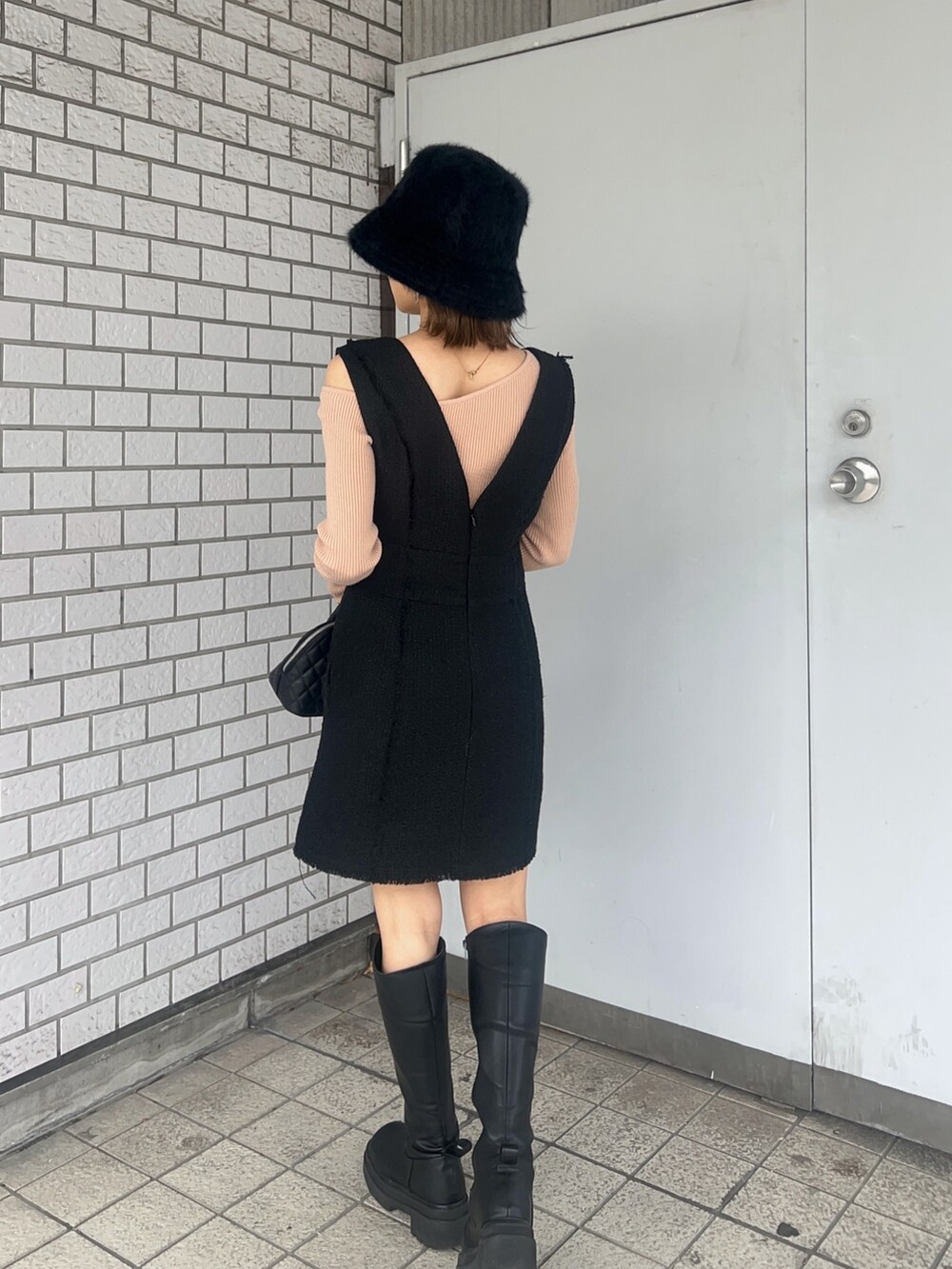 ベージュ系のニット/セーター、ブラック系のワンピース、ブラック系のブーツを着用したレディースの冬コーディネートの4枚目の写真