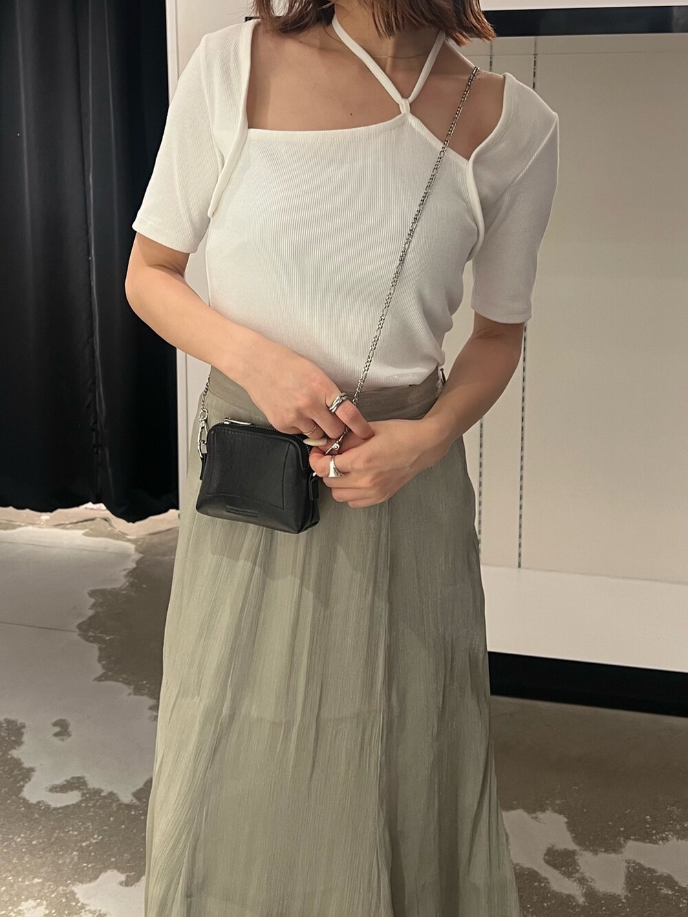 ブラック系のサンダル、ブラック系のショルダーバッグ、ホワイト系のTシャツ/カットソーを着用したレディースの夏コーディネートの6枚目の写真