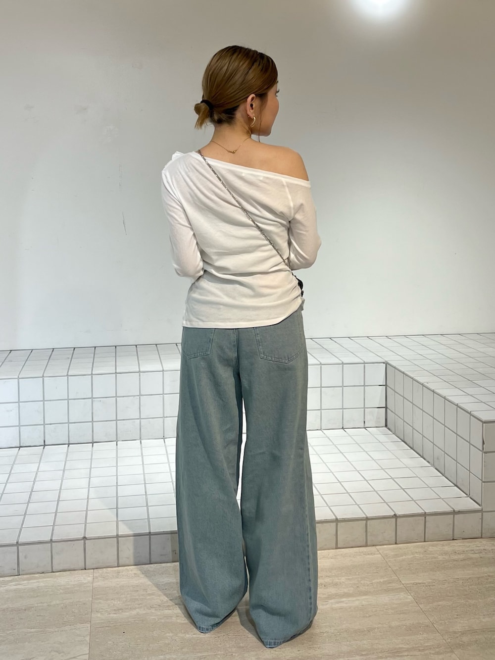 ホワイト系のTシャツ/カットソー、ブルー系のデニムパンツ、ブラック系のサンダルを着用したレディースの春コーディネートの3枚目の写真