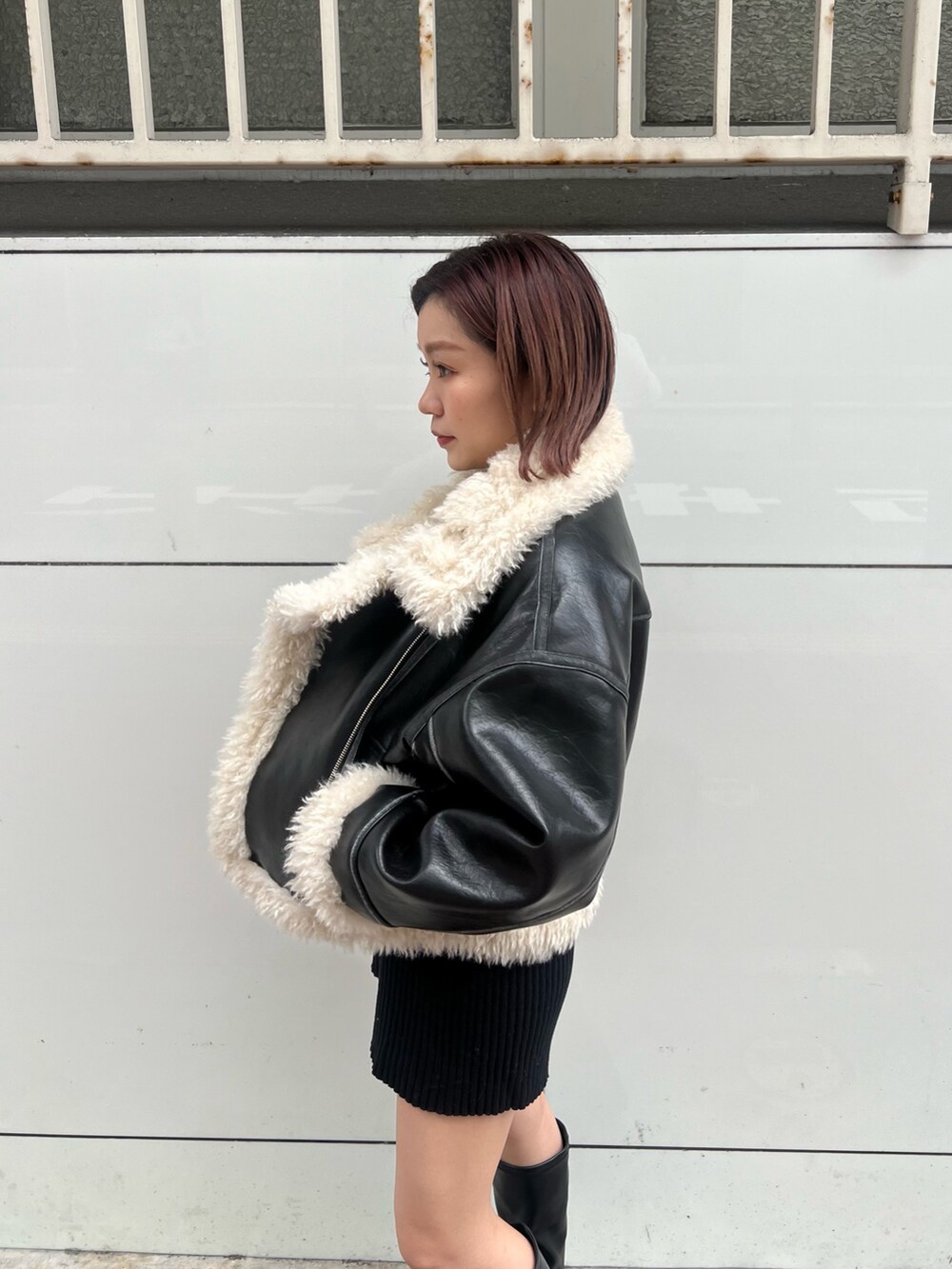 ブラック系のムートンコート、ブラック系のニット/セーター、ブラック系のその他パンツを着用したレディースの秋コーディネートの6枚目の写真