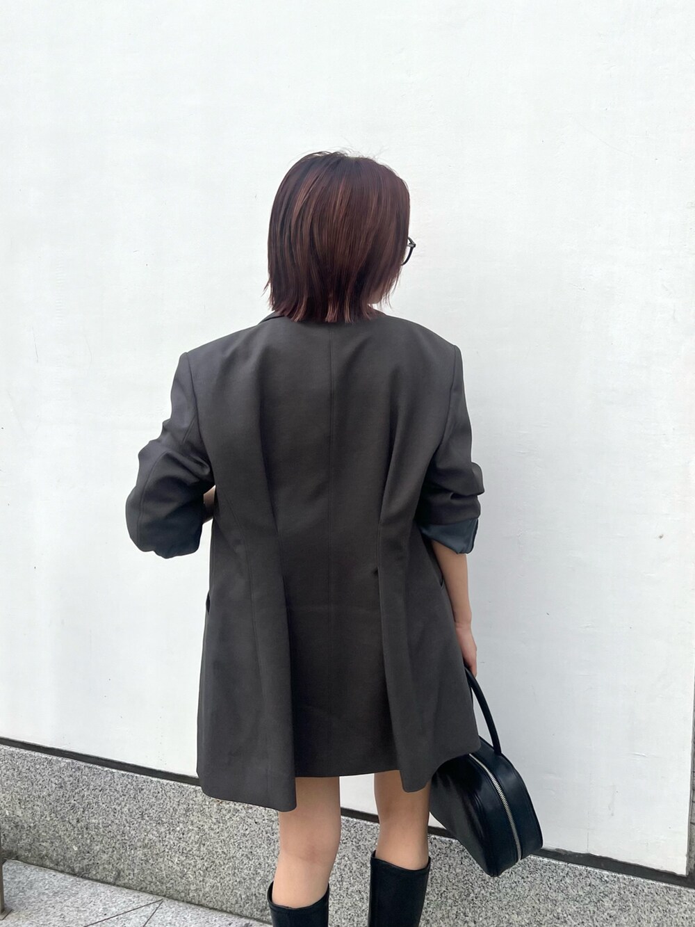 グレー系のテーラードジャケット、グレー系のその他パンツ、ブラック系のニット/セーターを着用したレディースの秋コーディネートの6枚目の写真