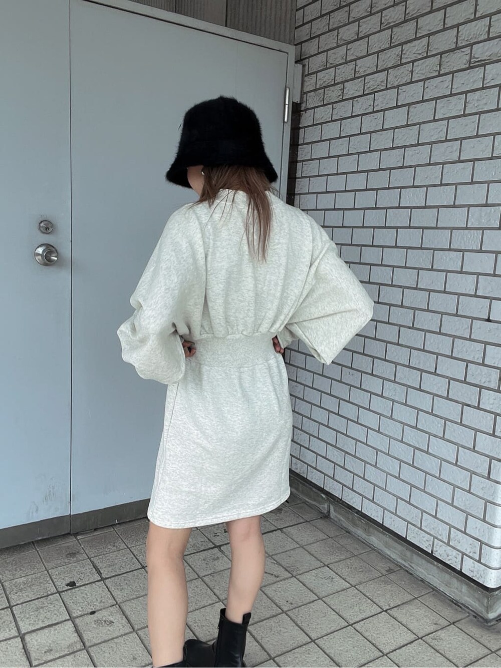 ホワイト系のワンピース、ブラック系のブーツ、ブラック系のブルゾンを着用したレディースの秋コーディネートの6枚目の写真