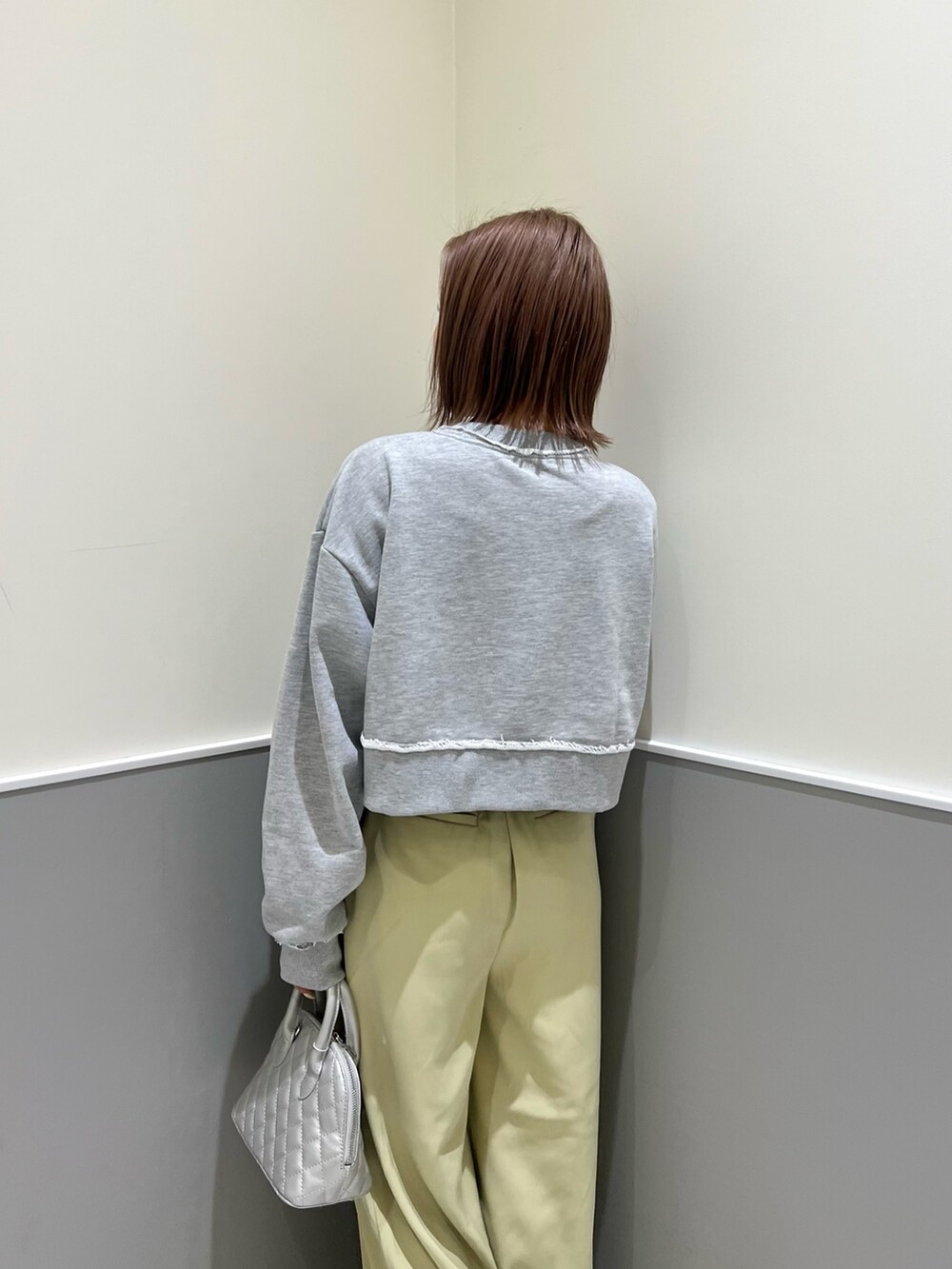 グレー系のスウェット、グリーン系のその他パンツ、シルバー系のハンドバッグを着用したレディースの冬コーディネートの5枚目の写真