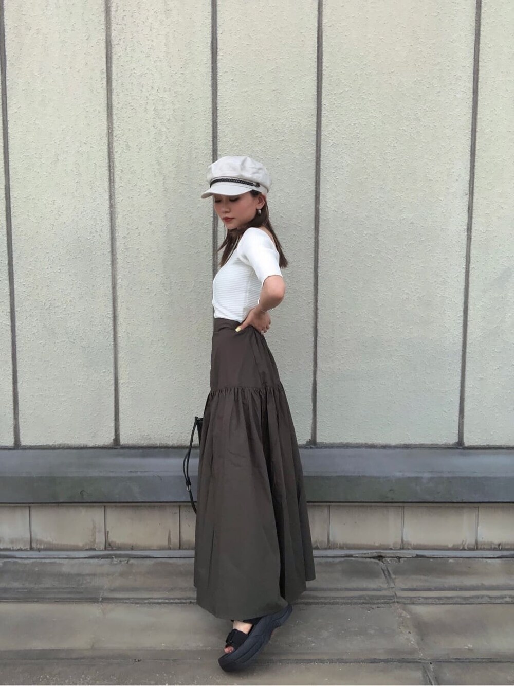 ブラック系のサンダル、ブラック系のショルダーバッグ、ホワイト系のニット/セーターを着用したレディースの夏コーディネートの4枚目の写真