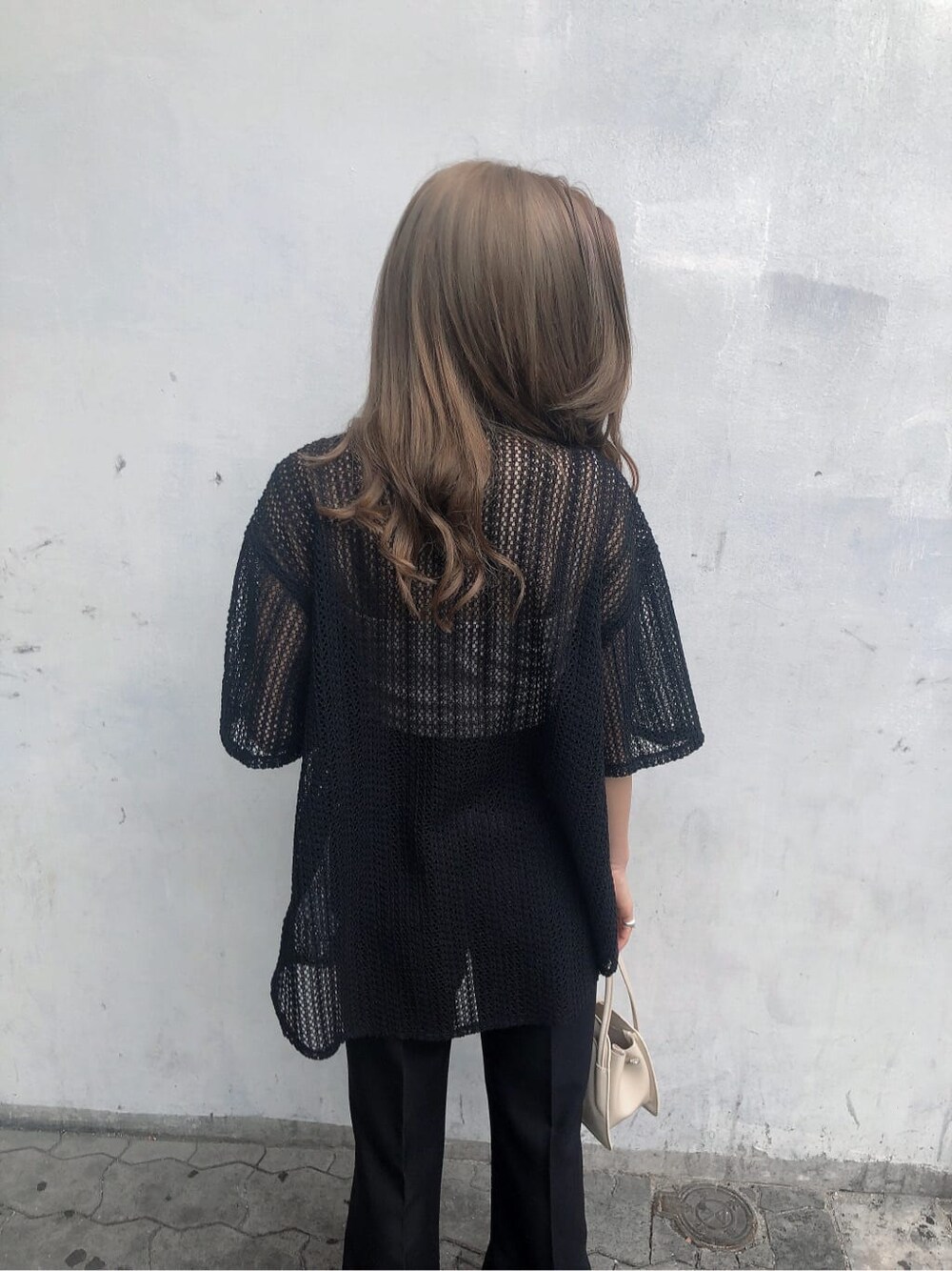 ブラック系のスラックス、ホワイト系のサンダル、ブラック系のシャツ/ブラウスを着用したレディースの春コーディネートの5枚目の写真