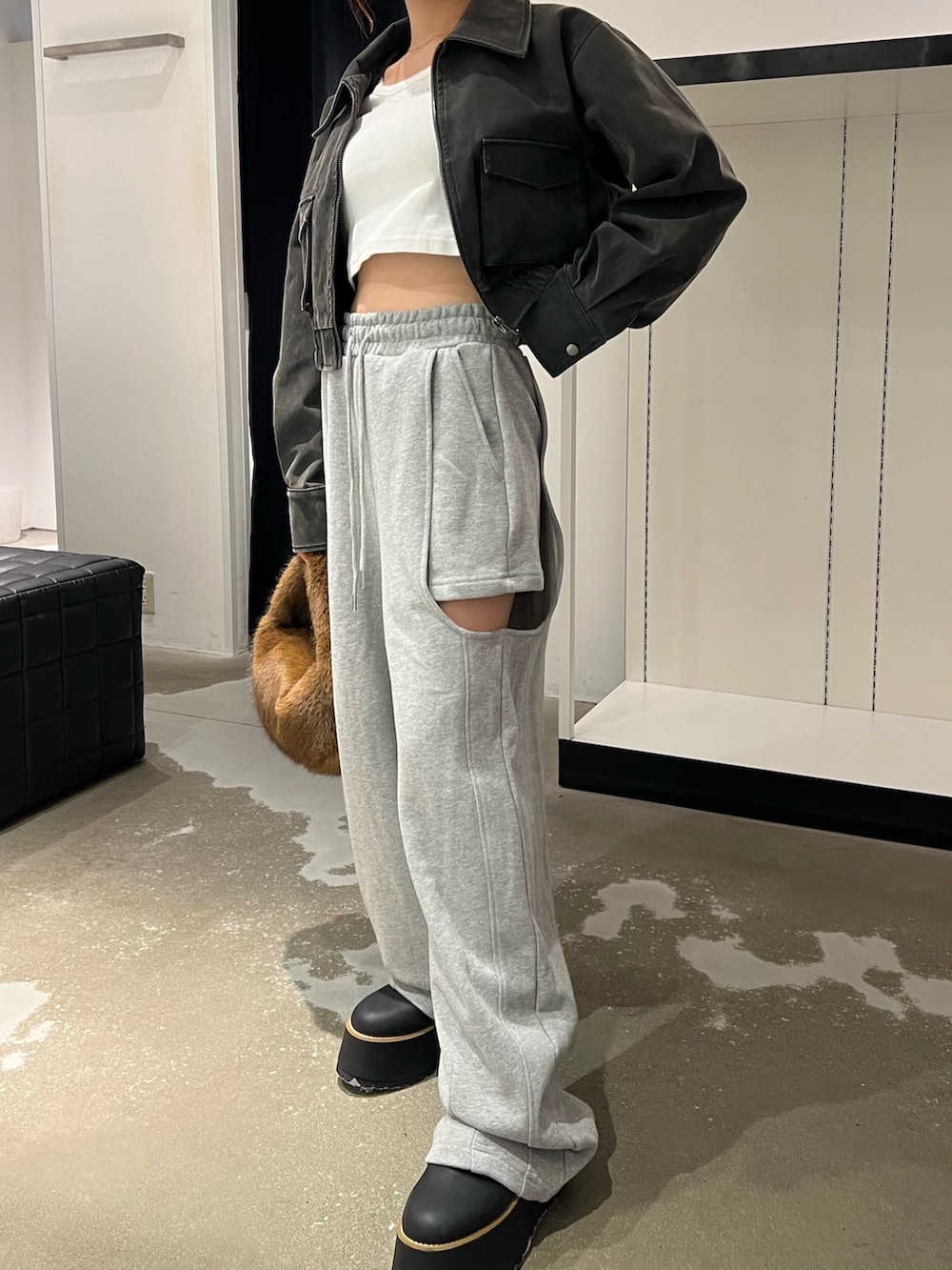 ブラック系のブルゾン、ホワイト系のTシャツ/カットソー、グレー系のスウェットパンツを着用したレディースの秋コーディネートの7枚目の写真