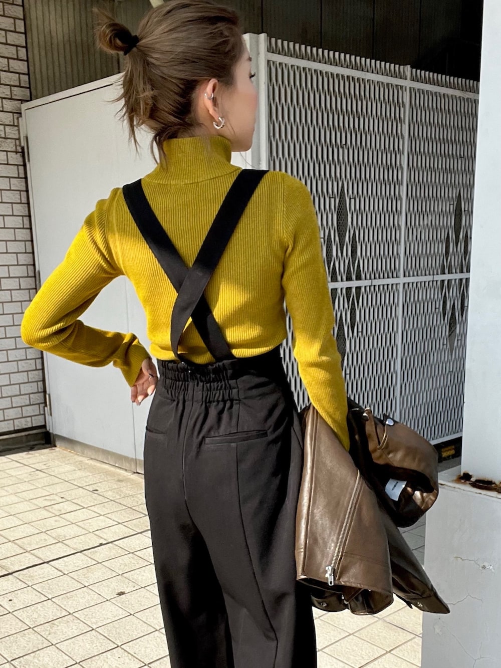 ブラウン系のライダースジャケット、ブラック系のスラックス、ブラック系のローファーを着用したレディースの秋コーディネートの8枚目の写真