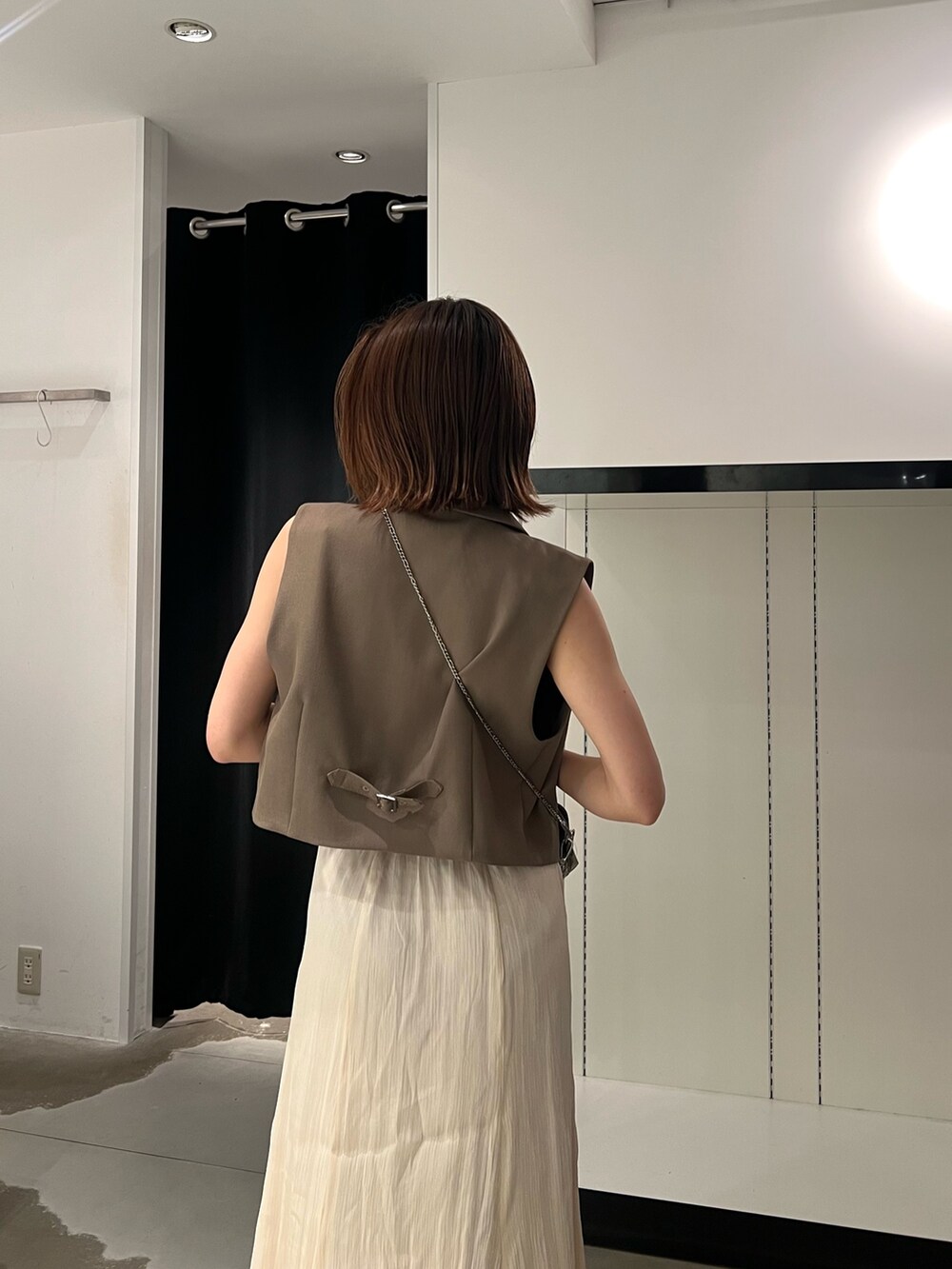 ブラック系のサンダル、ホワイト系のスカート、ゴールド系のショルダーバッグを着用したレディースの夏コーディネートの5枚目の写真