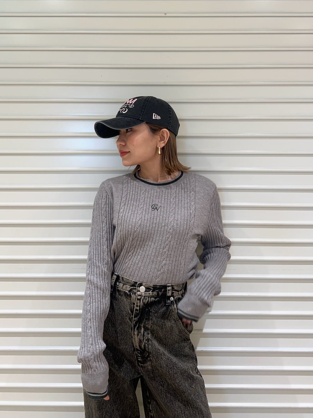 グレー系のニット/セーター、ブラック系のデニムパンツ、ブラック系のキャップを着用したレディースの冬コーディネートの4枚目の写真