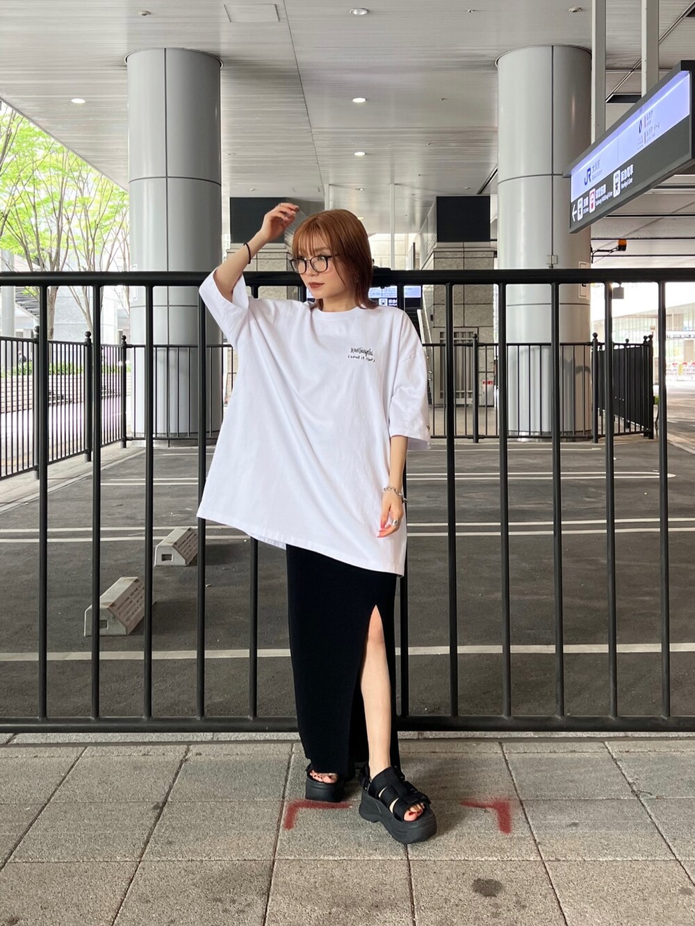 ブラック系のサンダル、ブラック系のスカート、ホワイト系のTシャツ/カットソーを着用したレディースの春コーディネートの2枚目の写真