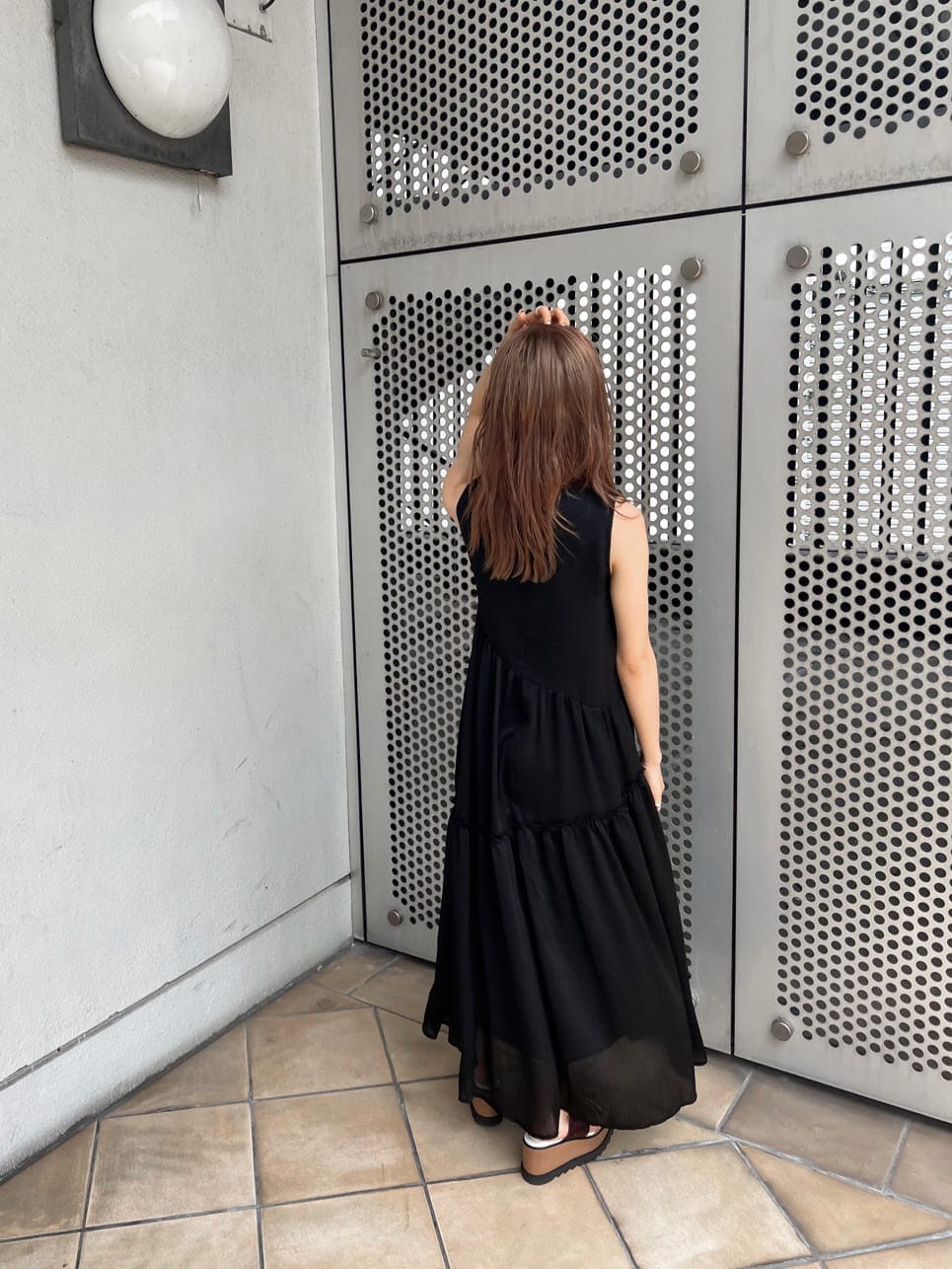 ブラック系のワンピース、ブラック系のハンドバッグ、その他のサンダルを着用したレディースの夏コーディネートの3枚目の写真