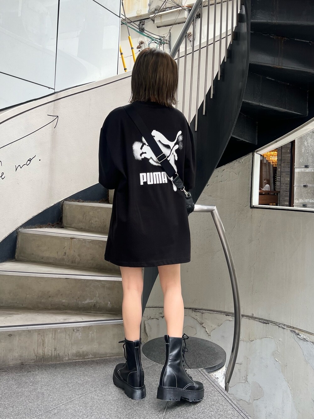 ブラック系のTシャツ/カットソー、ブラック系のブーツ、ブラック系のショルダーバッグを着用したレディースの春コーディネートの2枚目の写真