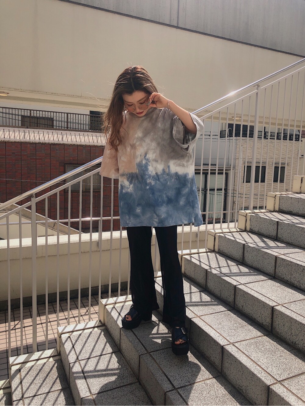 ブラック系のスラックス、ブラック系のサンダル、その他のTシャツ/カットソーを着用したレディースの春コーディネートの3枚目の写真