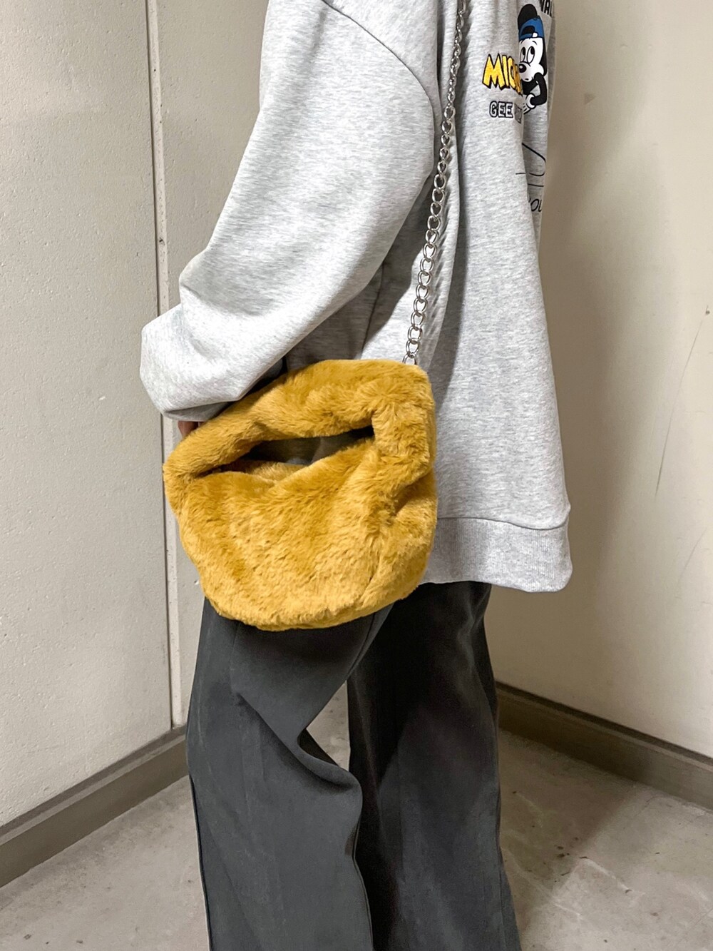 グレー系のスウェット、グレー系のその他パンツ、イエロー系のハンドバッグを着用したレディースの秋コーディネートの7枚目の写真