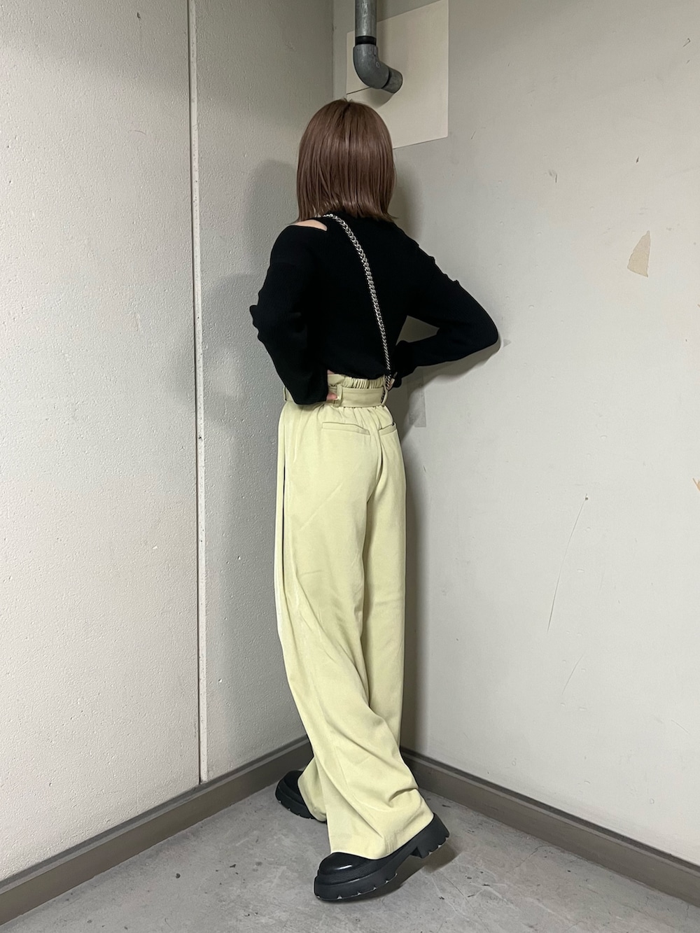 ブラック系のニット/セーター、ブラック系のハンドバッグ、ブラック系のブーツを着用したレディースの冬コーディネートの3枚目の写真