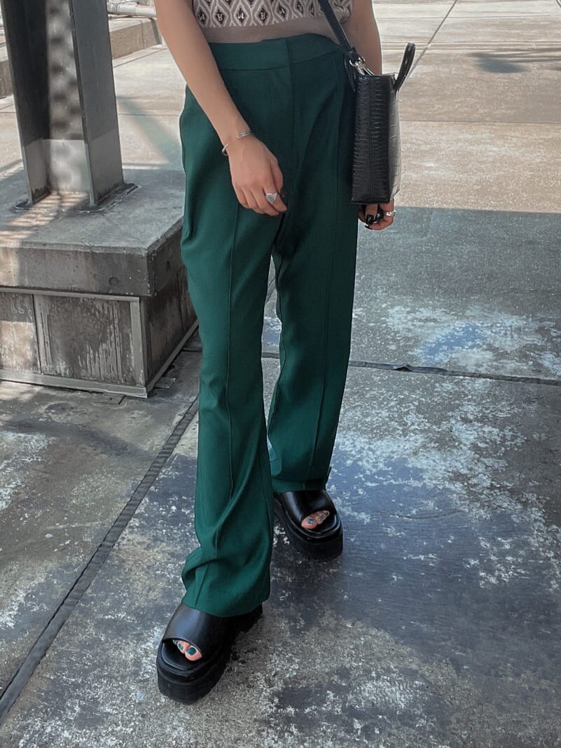 ベージュ系のニット/セーター、グリーン系のスラックスを着用したレディースの夏コーディネートの8枚目の写真