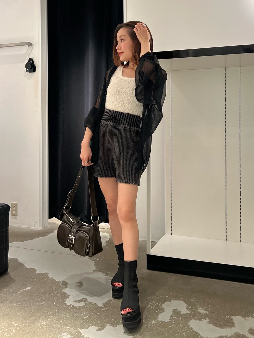 ブラック系のシャツ/ブラウス、ホワイト系のニット/セーター、ブラウン系のハンドバッグを着用したレディースの夏コーディネートの3枚目の写真