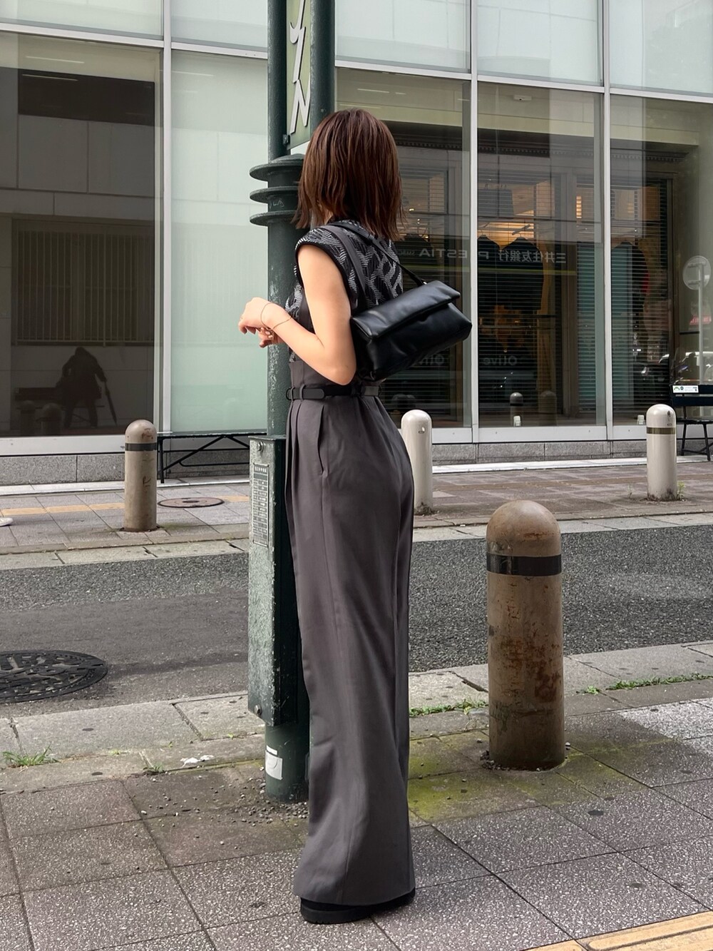 ブラック系のニット/セーター、グレー系のその他パンツ、ブラック系のハンドバッグを着用したレディースの夏コーディネートの3枚目の写真