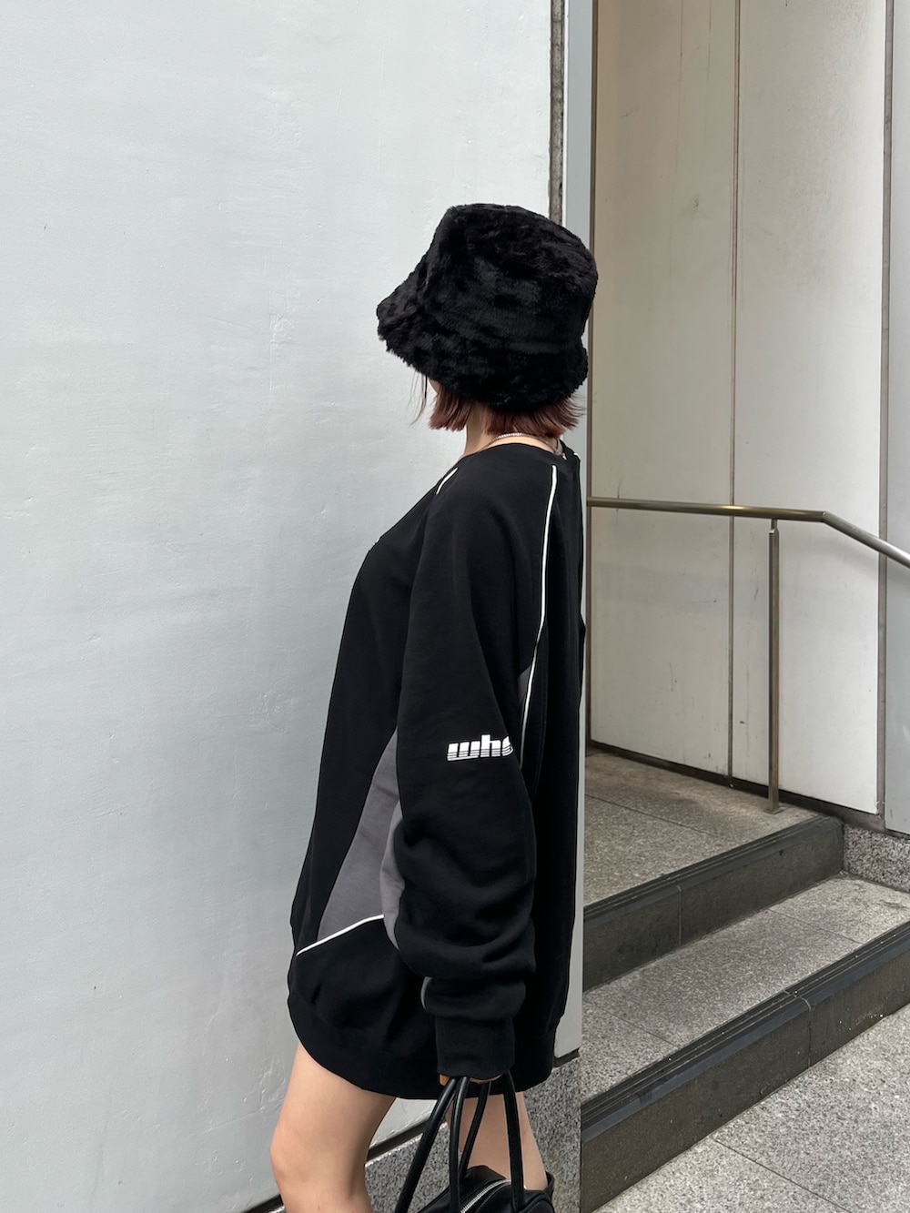 ブラック系のスウェット、ブラック系のブーツ、ブラック系のハットを着用したレディースの秋コーディネートの7枚目の写真