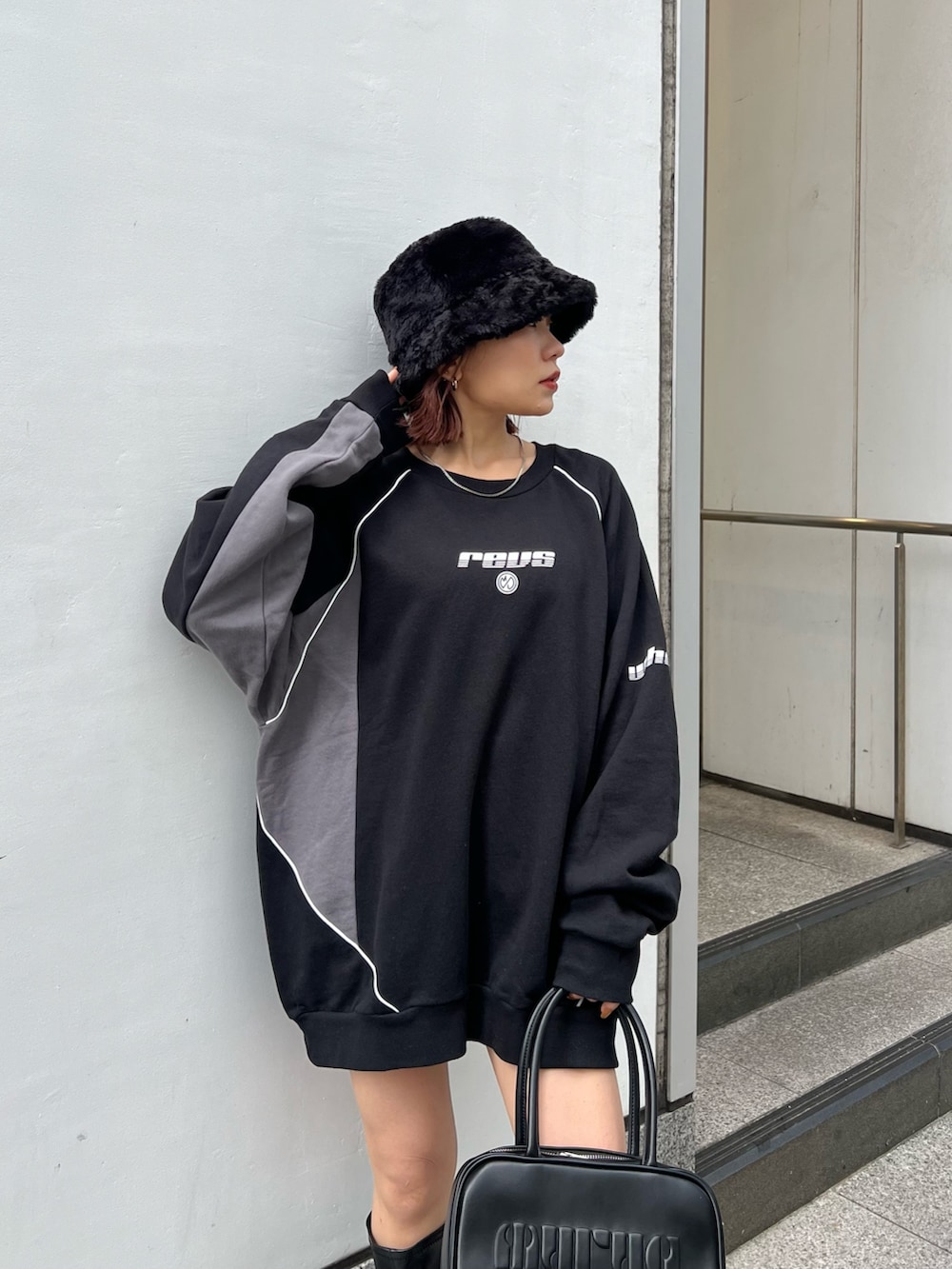 ブラック系のスウェット、ブラック系のブーツ、ブラック系のハットを着用したレディースの秋コーディネートの5枚目の写真