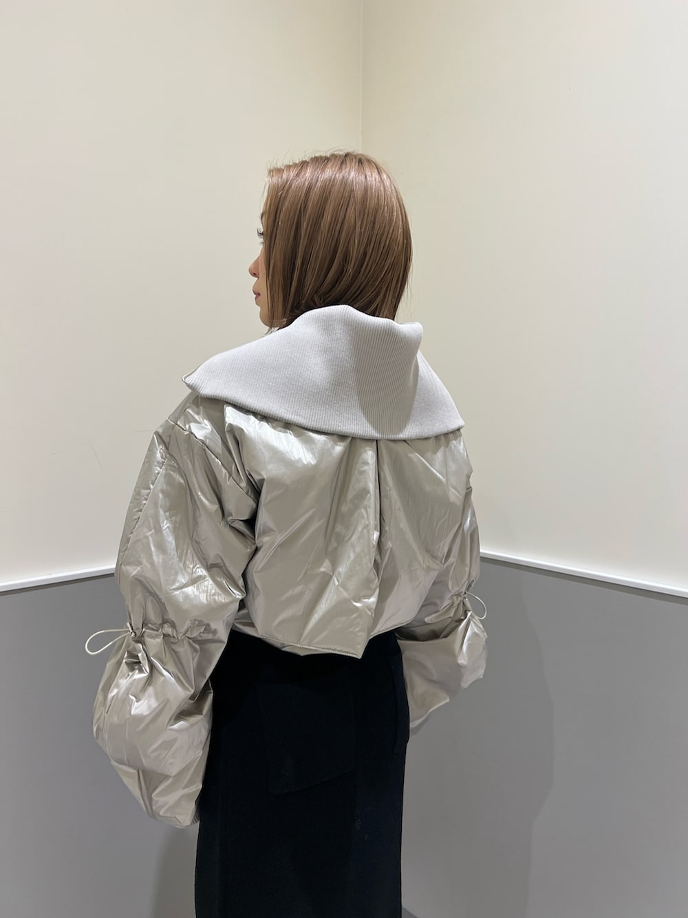 ブラック系のニット/セーター、シルバー系のブルゾン、ブラック系のスカートを着用したレディースの冬コーディネートの7枚目の写真