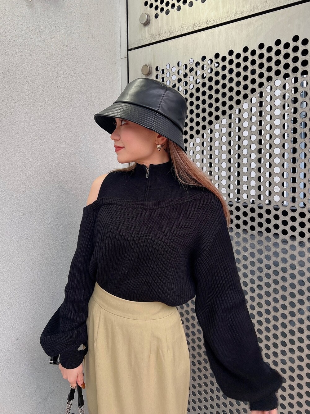 グリーン系のスカート、ブラック系のニット/セーター、ブラック系のショルダーバッグを着用したレディースの冬コーディネートの6枚目の写真