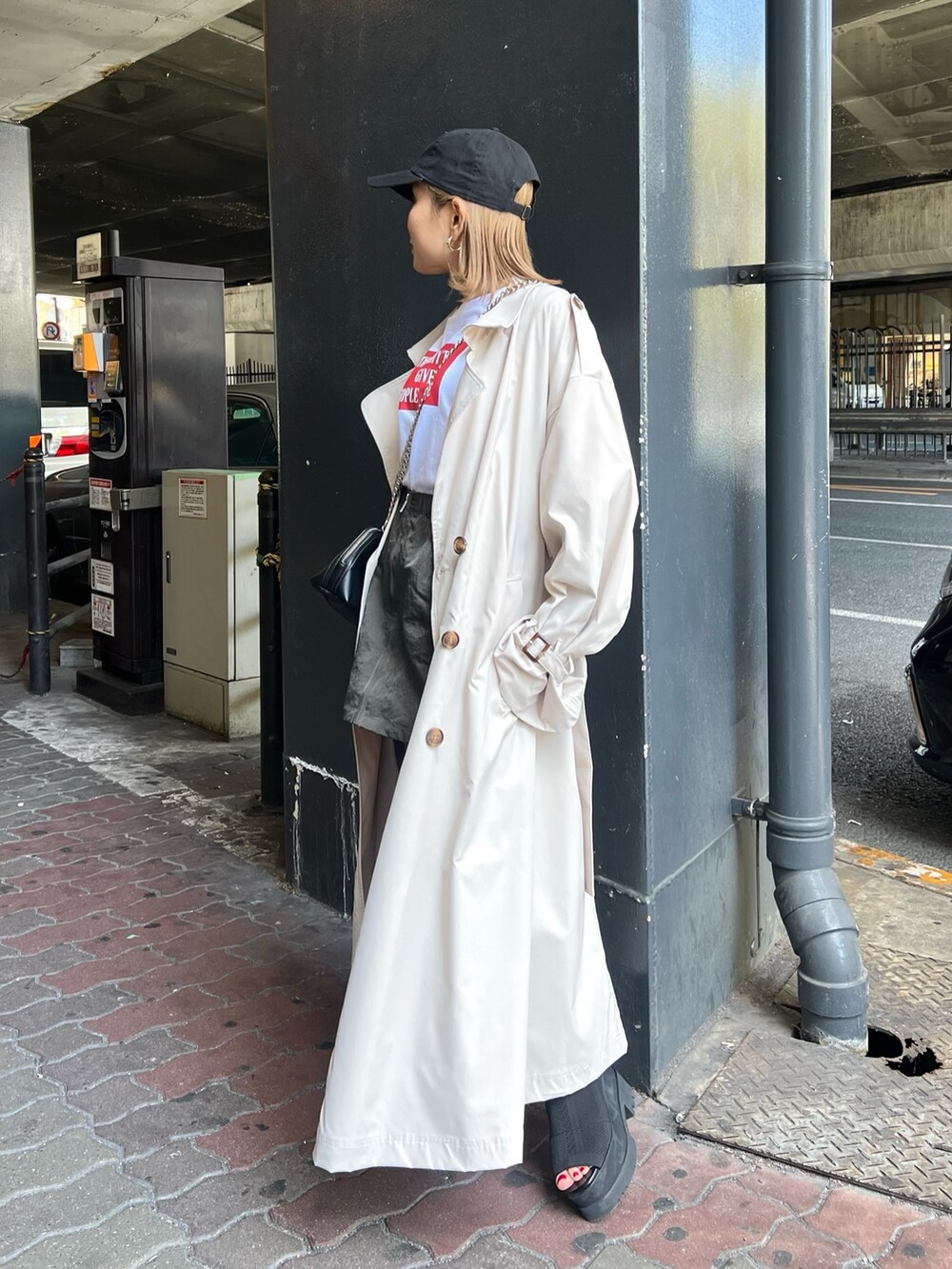 ブラック系のブーツ、ホワイト系のトレンチコート、ホワイト系のTシャツ/カットソーを着用したレディースの春コーディネートの2枚目の写真