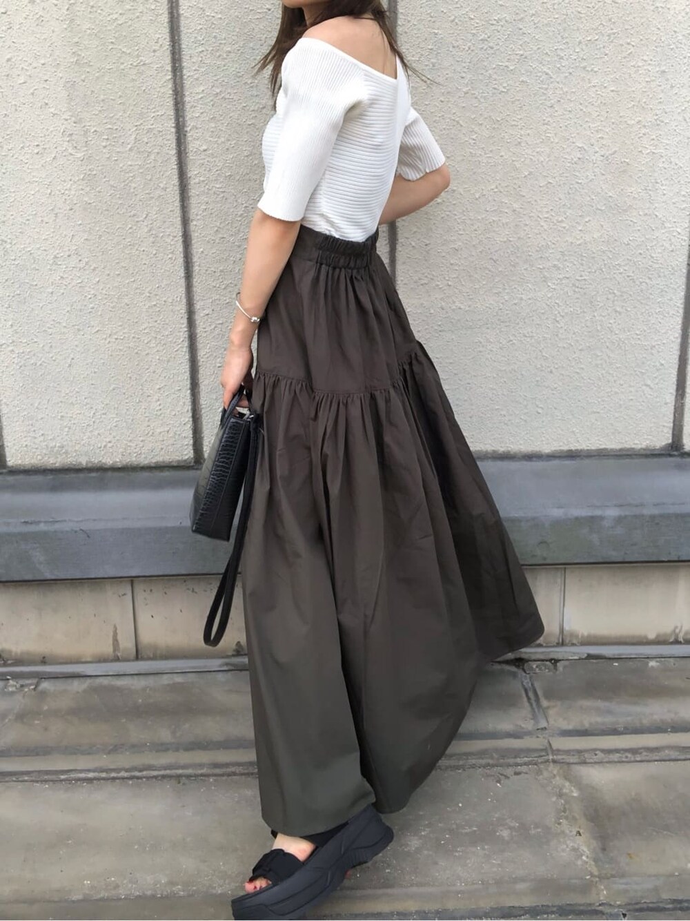 ブラック系のサンダル、ブラック系のショルダーバッグ、ホワイト系のニット/セーターを着用したレディースの夏コーディネートの7枚目の写真