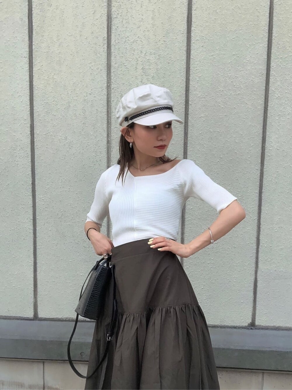 ブラック系のサンダル、ブラック系のショルダーバッグ、ホワイト系のニット/セーターを着用したレディースの夏コーディネートの5枚目の写真