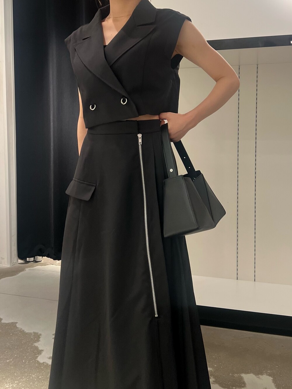 ブラック系のワンピース、ブラック系のサンダル、ブラック系のハンドバッグを着用したレディースの夏コーディネートの7枚目の写真