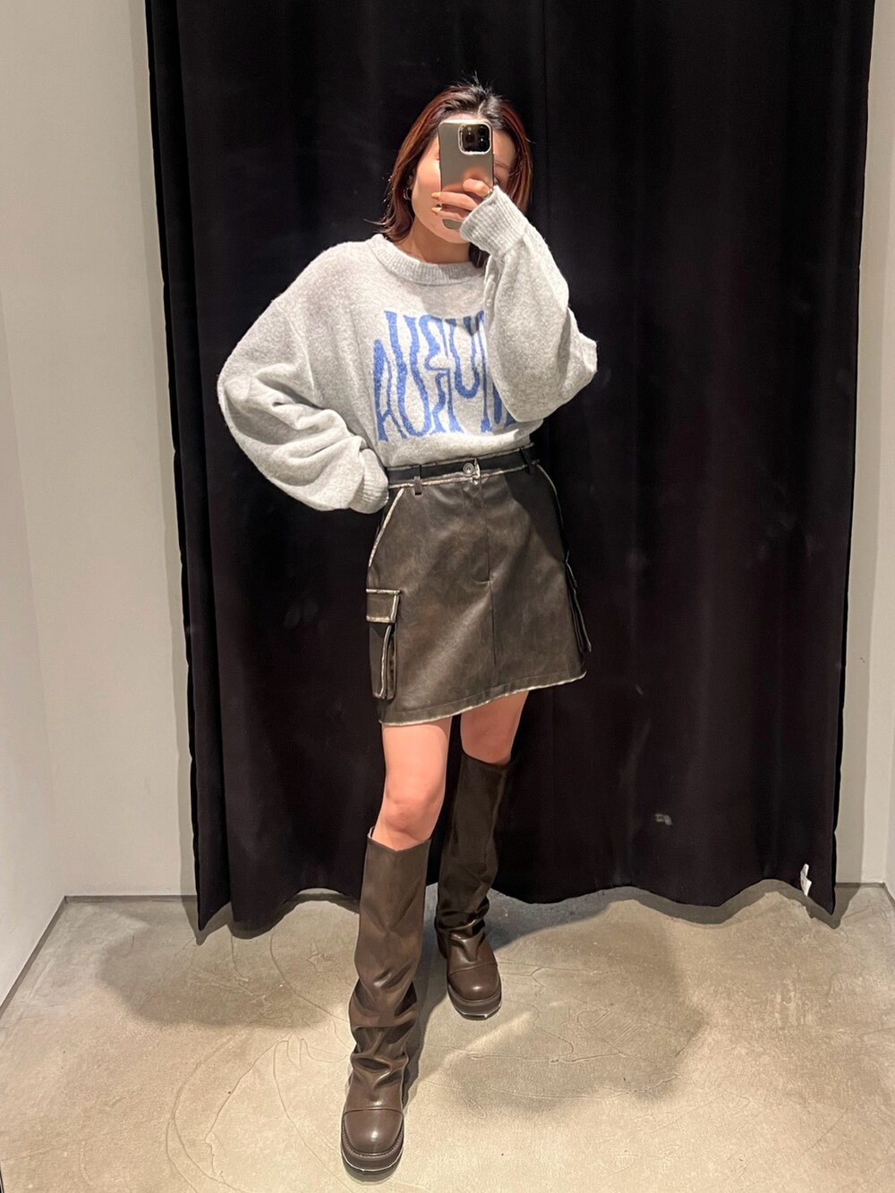 グレー系のニット/セーター、ブラウン系のブーツ、ブラウン系のスカートを着用したレディースの冬コーディネートの3枚目の写真