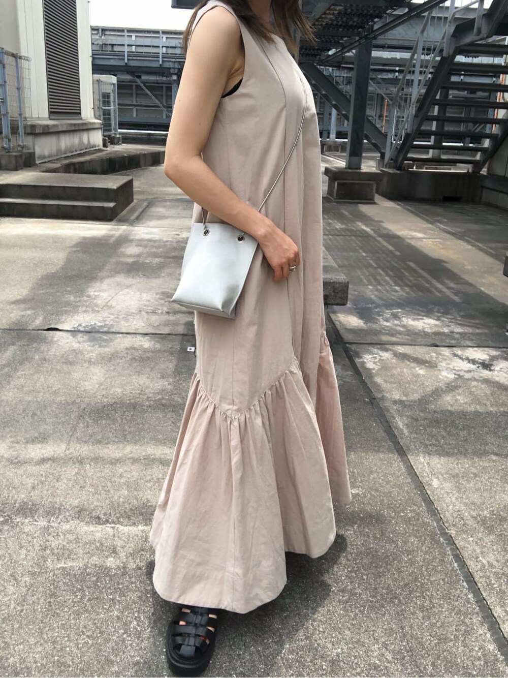 ベージュ系のワンピース、ブラック系のサンダル、ホワイト系のショルダーバッグを着用したレディースの夏コーディネートの9枚目の写真