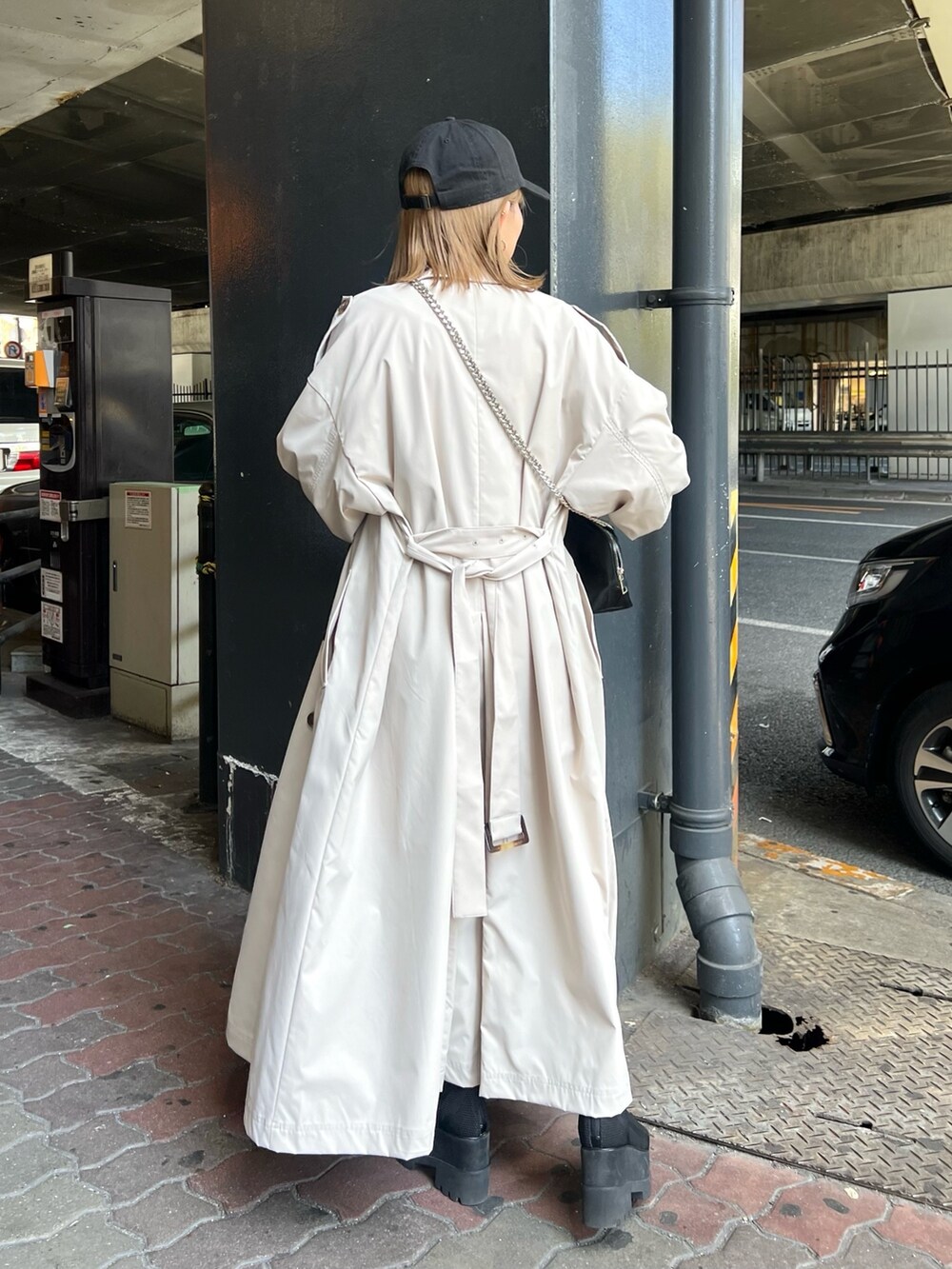 ブラック系のブーツ、ホワイト系のトレンチコート、ホワイト系のTシャツ/カットソーを着用したレディースの春コーディネートの3枚目の写真