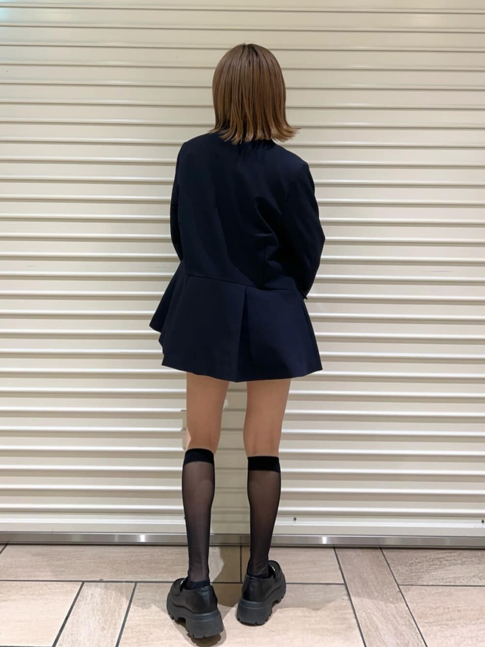 グレー系のニット/セーター、ブラック系のその他パンツ、ブルー系のノーカラージャケットを着用したレディースの冬コーディネートの3枚目の写真