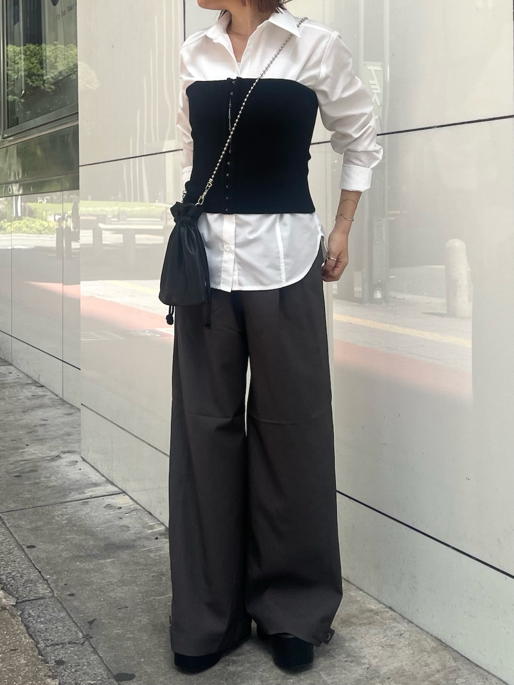 ブラック系のブーツ、ホワイト系のシャツ/ブラウス、ブラック系のニット/セーターを着用したレディースの秋コーディネートの8枚目の写真