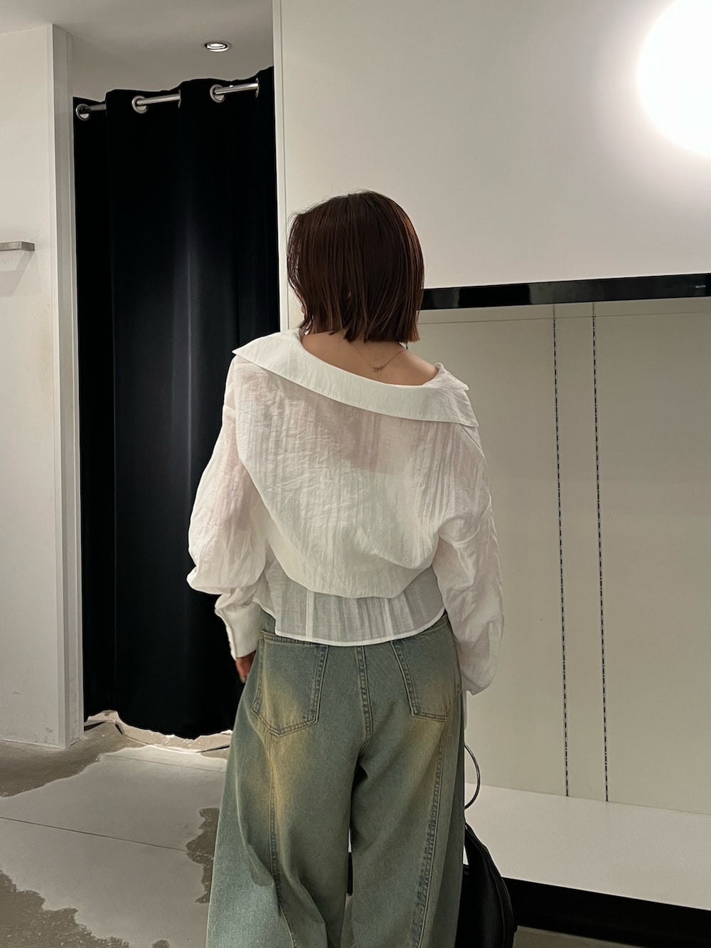 ホワイト系のシャツ/ブラウス、ブルー系のデニムパンツ、ブラック系のハンドバッグを着用したレディースの夏コーディネートの6枚目の写真