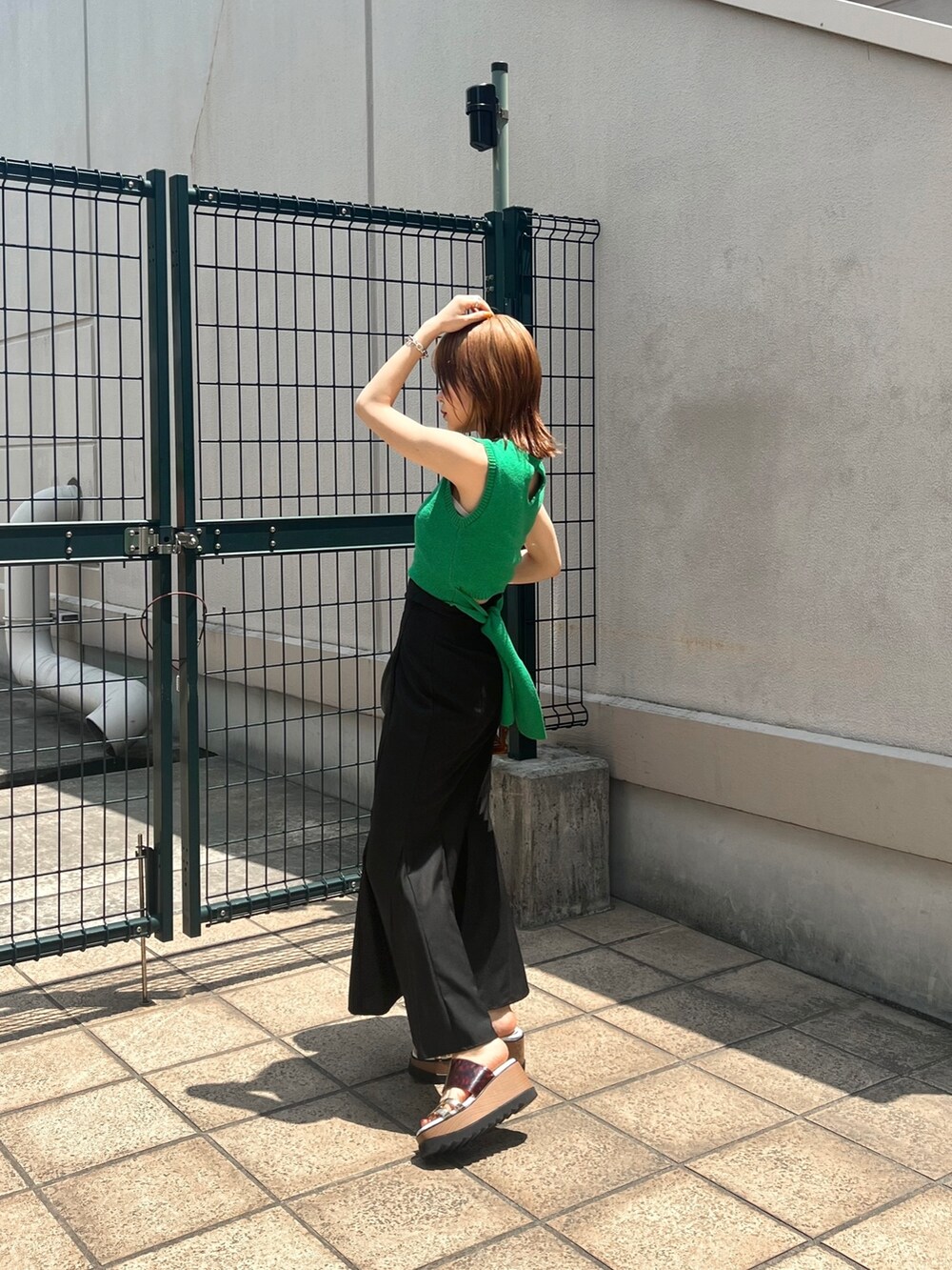 グリーン系のタンクトップ、ブラック系のスカート、その他のサンダルを着用したレディースの夏コーディネートの4枚目の写真