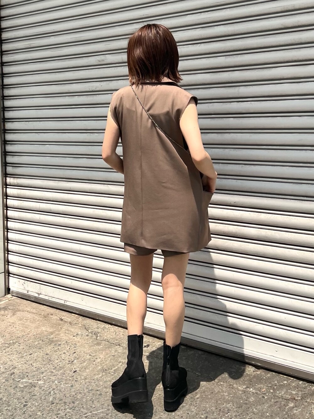 ブラウン系のベスト、ブラウン系のその他パンツ、ブラック系のキャミソールを着用したレディースの夏コーディネートの3枚目の写真