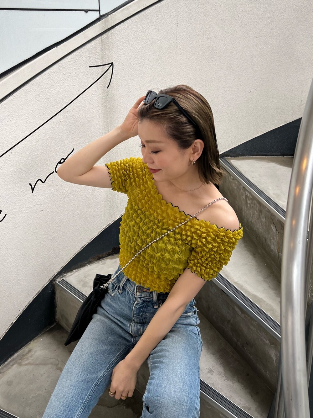 ブラック系のショルダーバッグ、イエロー系のシャツ/ブラウス、ブラック系のサングラスを着用したレディースの春コーディネートの5枚目の写真