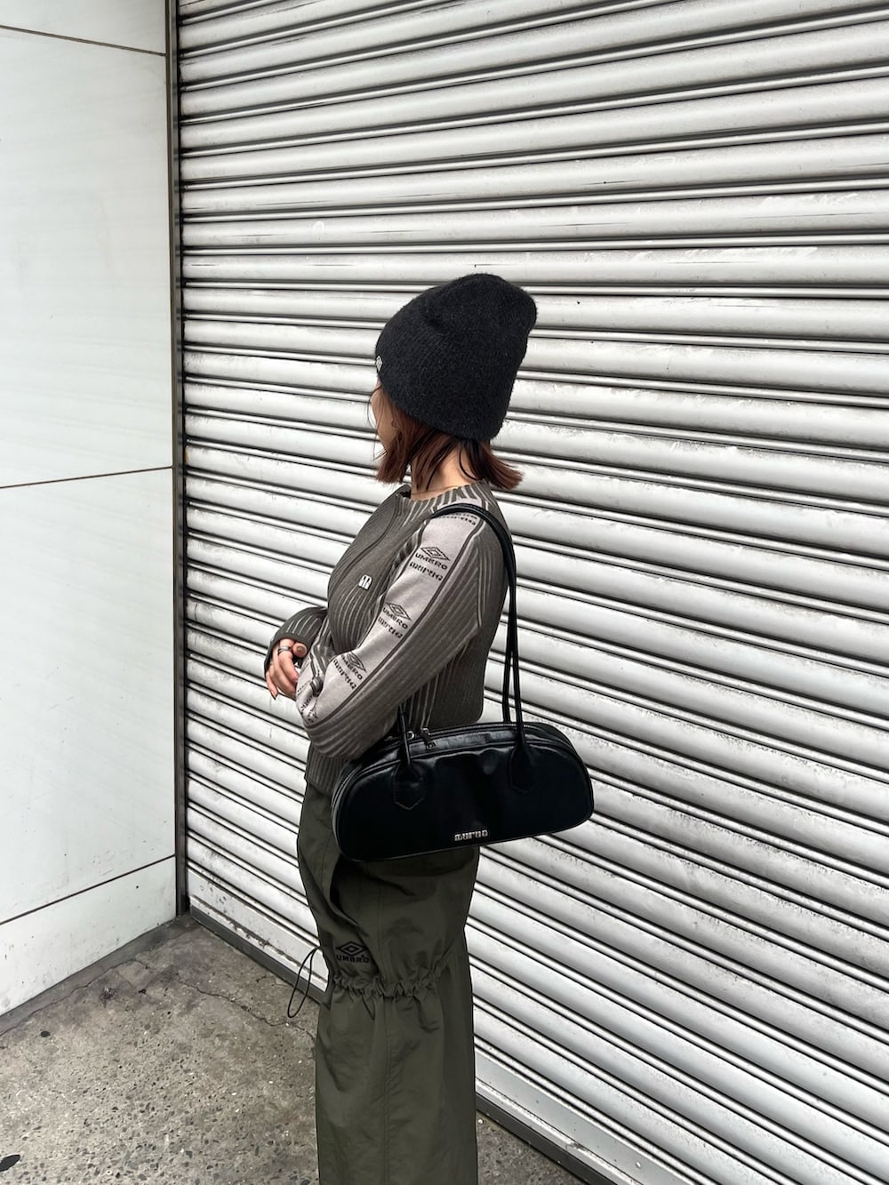 ブラック系のブーツ、グリーン系のニット/セーター、グリーン系のスカートを着用したレディースの秋コーディネートの5枚目の写真