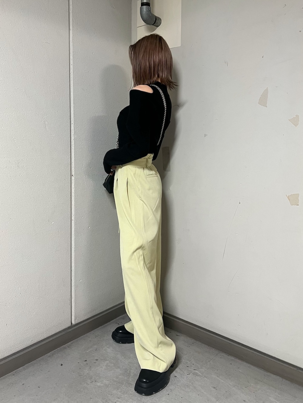 ブラック系のニット/セーター、ブラック系のハンドバッグ、ブラック系のブーツを着用したレディースの冬コーディネートの2枚目の写真