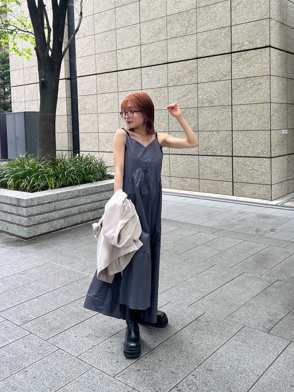 ベージュ系のテーラードジャケット、ブラウン系のニット/セーター、グレー系のワンピースを着用したレディースの春コーディネートの2枚目の写真