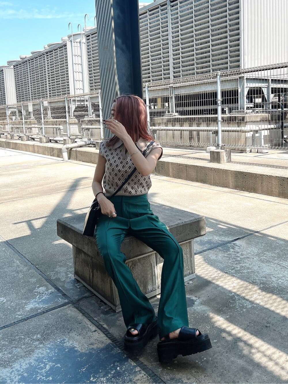 ベージュ系のニット/セーター、グリーン系のスラックスを着用したレディースの夏コーディネートの2枚目の写真