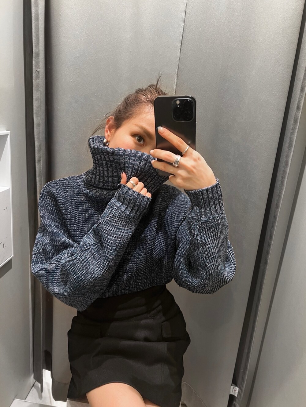 ブラック系のスカート、ブルー系のニット/セーター、ブラック系のブーツを着用したレディースの秋コーディネートの3枚目の写真