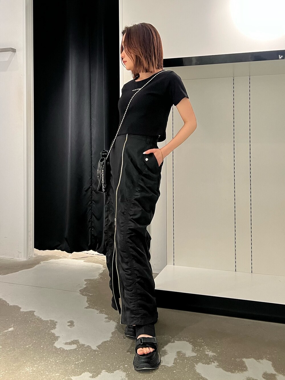 ブラック系のTシャツ/カットソー、ブラック系のサンダル、ブラック系のスカートを着用したレディースの春コーディネートの2枚目の写真