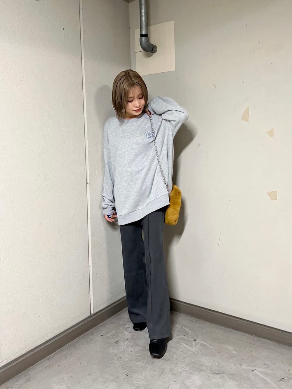 グレー系のスウェット、グレー系のその他パンツ、イエロー系のハンドバッグを着用したレディースの秋コーディネートの4枚目の写真